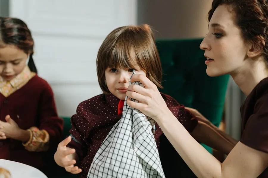 A childminder tending to a young child at home while another sits nearby, the kind of household setting where wear and tear adds up A childminder tending to a young child at home while another sits nearby, the kind of household setting where wear and tear adds up