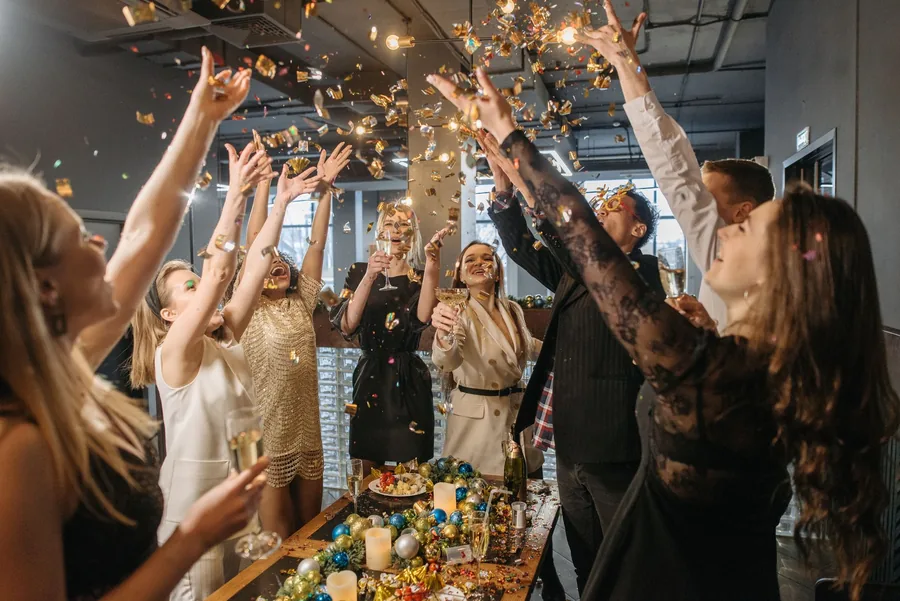Colleagues raising a toast at a work Christmas party. Keep the cost to £150 or less a head and the whole event stays tax-free.