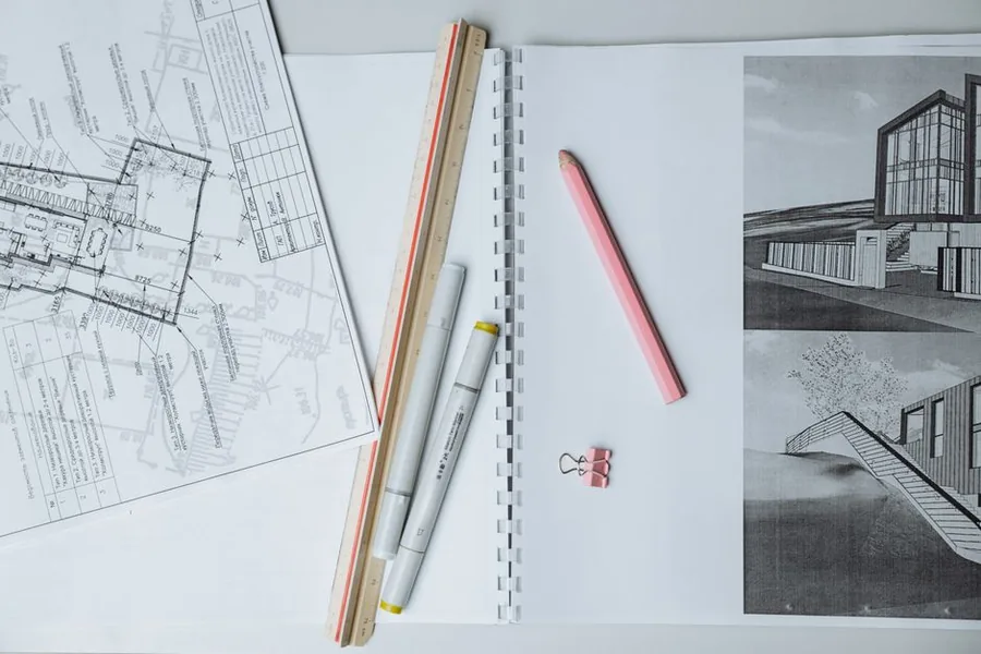A construction professional marking up building plans at a desk, the paperwork side of working under the Construction Industry Scheme A construction professional marking up building plans at a desk, the paperwork side of working under the Construction Industry Scheme