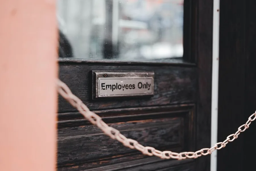 An Employees Only sign on a workplace door, marking the line between employed staff and self-employed subcontractors An Employees Only sign on a workplace door, marking the line between employed staff and self-employed subcontractors