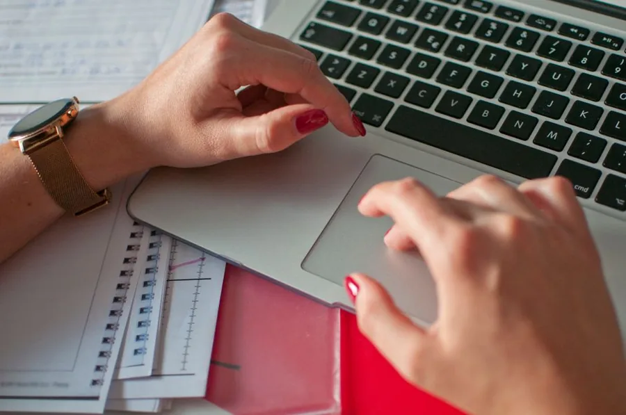 An accountant reviewing a limited company's final accounts and paperwork with a calculator before it is wound up
