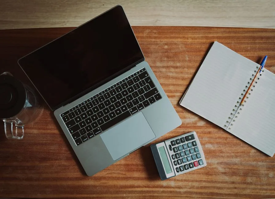 A laptop, calculator and notebook laid out to process CIS payroll deductions for construction subcontractors A laptop, calculator and notebook laid out to process CIS payroll deductions for construction subcontractors