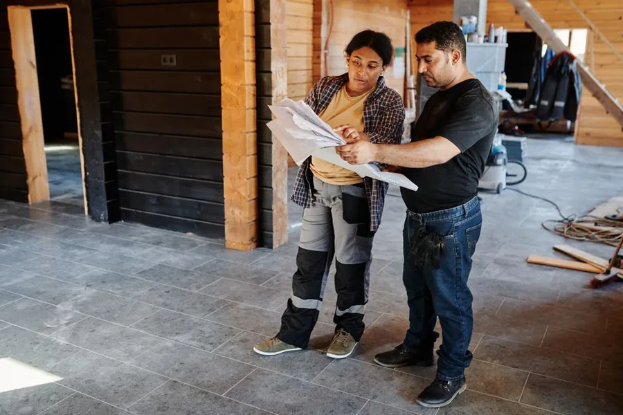 Two contractors reviewing paperwork on site, weighing up which running costs their limited company can claim as expenses Two contractors reviewing paperwork on site, weighing up which running costs their limited company can claim as expenses