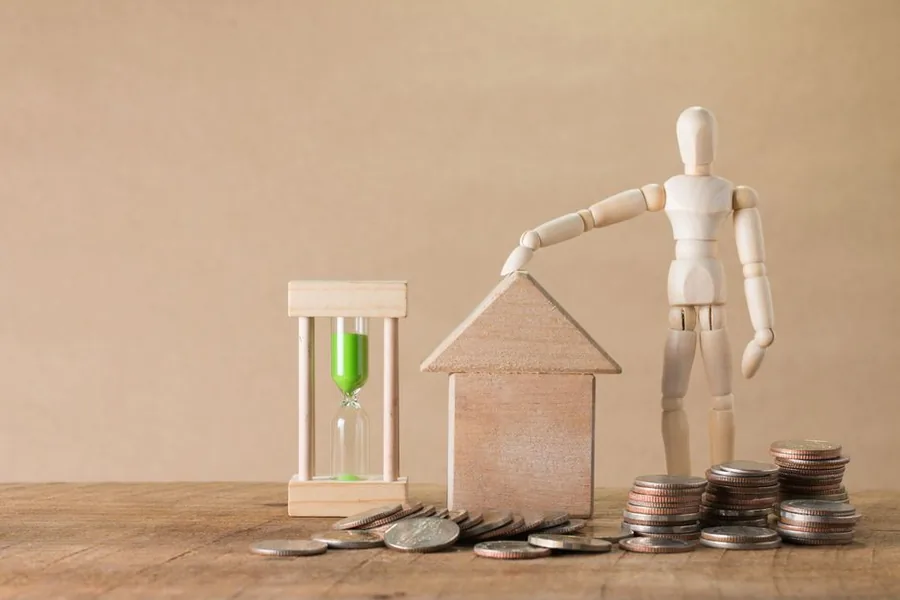 A calculator and a house-shaped keyring resting on printed mortgage rate sheets and homebuyer guides A calculator and a house-shaped keyring resting on printed mortgage rate sheets and homebuyer guides