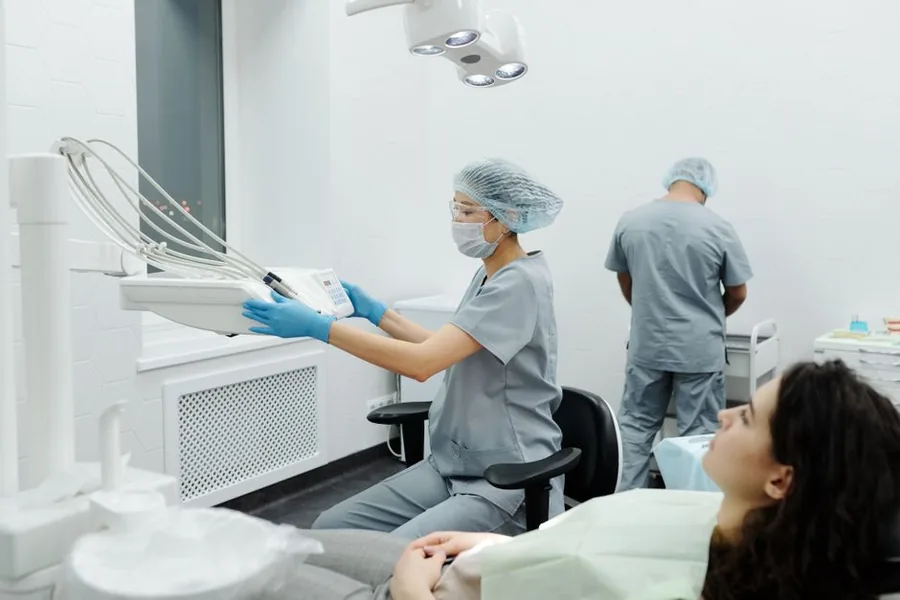 A dental hygienist preparing equipment in a bright, modern UK dental practice surgery A dental hygienist preparing equipment in a bright, modern UK dental practice surgery
