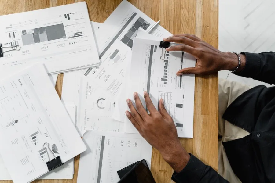 A company director sorting through financial paperwork while preparing dividend vouchers and board meeting minutes A company director sorting through financial paperwork while preparing dividend vouchers and board meeting minutes