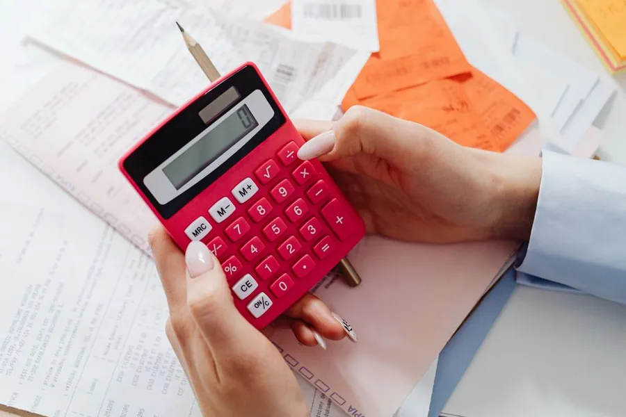 A company director working out the dividend tax due on a calculator alongside their paperwork A company director working out the dividend tax due on a calculator alongside their paperwork