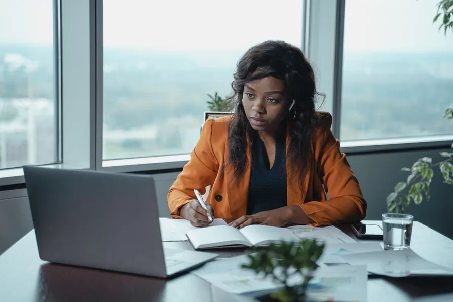 A limited company director reviewing accounts and financial paperwork at her laptop before deciding whether to hire an accountant A limited company director reviewing accounts and financial paperwork at her laptop before deciding whether to hire an accountant