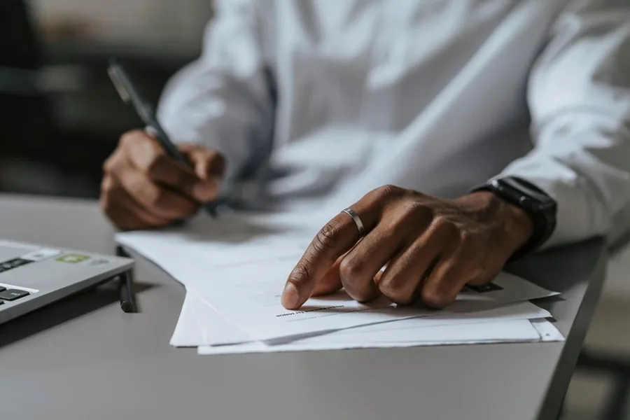 Working through paperwork with a calculator to check whether a UK self assessment tax return is due Working through paperwork with a calculator to check whether a UK self assessment tax return is due