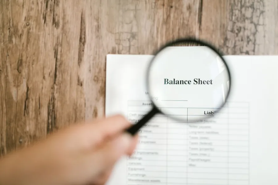 A magnifying glass held over a company balance sheet, the core statement dormant firms still file at Companies House A magnifying glass held over a company balance sheet, the core statement dormant firms still file at Companies House