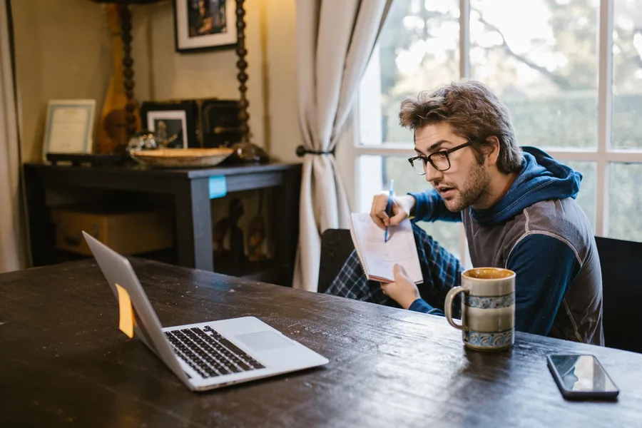 A sole trader at home working through his electricity bill with a notepad and laptop, checking the VAT rate and monthly kWh usage against the de minimis limit A sole trader at home working through his electricity bill with a notepad and laptop, checking the VAT rate and monthly kWh usage against the de minimis limit