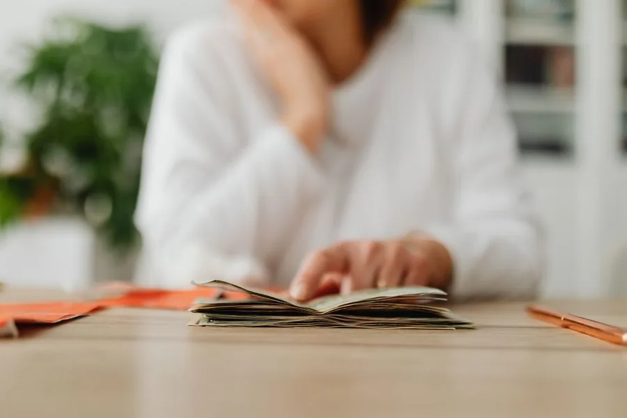 Reviewing personal finances at a home desk while planning savings and everyday budgeting decisions