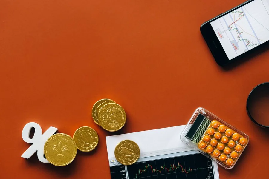 A percentage symbol beside pound coins and a calculator, weighing up VAT rates to see which scheme saves an ecommerce seller money A percentage symbol beside pound coins and a calculator, weighing up VAT rates to see which scheme saves an ecommerce seller money