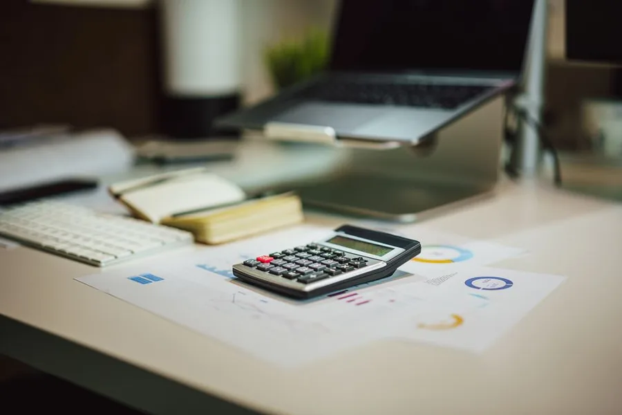 A calculator resting on financial performance charts beside a laptop, the kind of figures FRS 102 accounts pull together A calculator resting on financial performance charts beside a laptop, the kind of figures FRS 102 accounts pull together