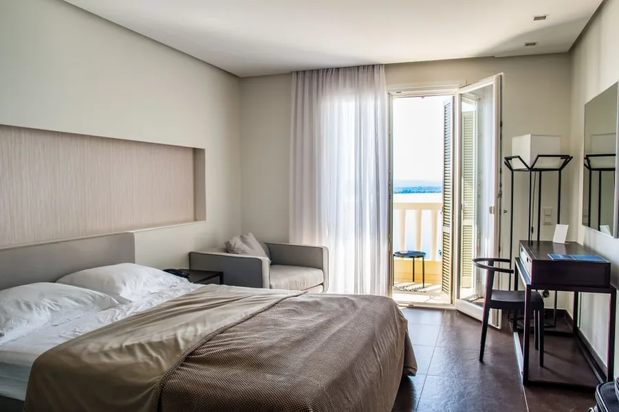 A bright furnished holiday let bedroom with a balcony and sea view, the kind of short-term rental hit by the FHL regime abolition