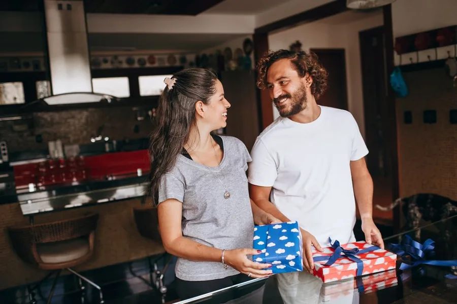 A married couple exchanging wrapped gifts at home, reflecting how spousal gift transfers are treated for CGT and IHT A married couple exchanging wrapped gifts at home, reflecting how spousal gift transfers are treated for CGT and IHT