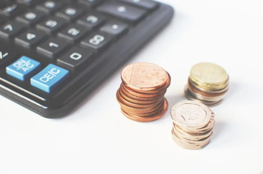 Stacks of UK coins beside a calculator while working out whether earnings trigger the High Income Child Benefit Charge Stacks of UK coins beside a calculator while working out whether earnings trigger the High Income Child Benefit Charge