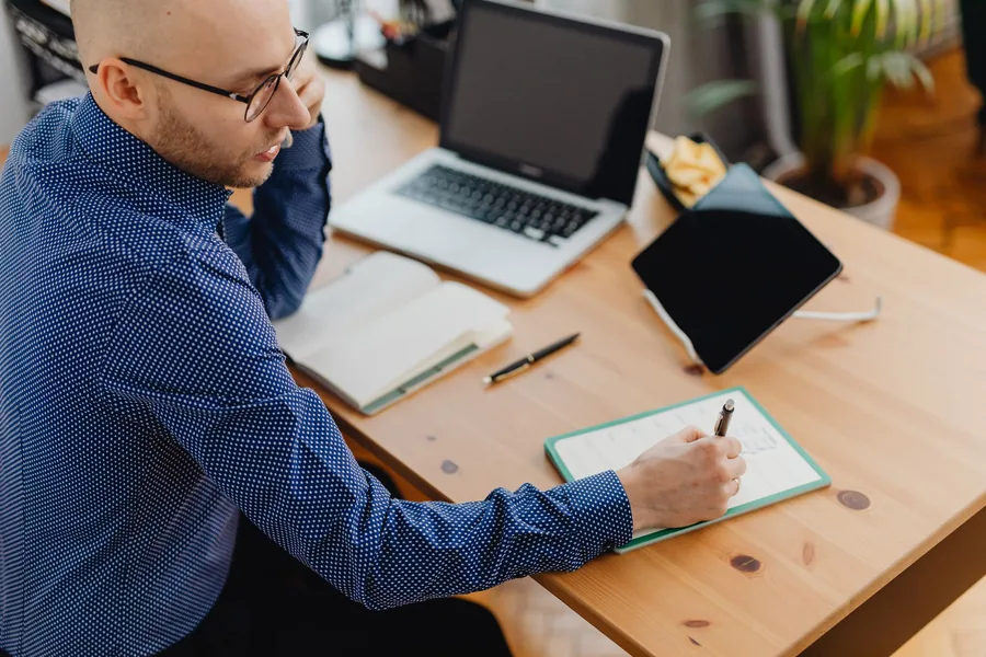 A UK home worker signing in to an online government service at a laptop in a bright, tidy home office A UK home worker signing in to an online government service at a laptop in a bright, tidy home office