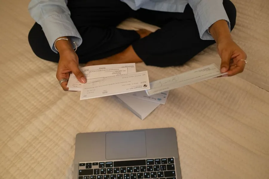A UK online seller going through bank statements and a laptop to check their records after receiving an HMRC letter A UK online seller going through bank statements and a laptop to check their records after receiving an HMRC letter