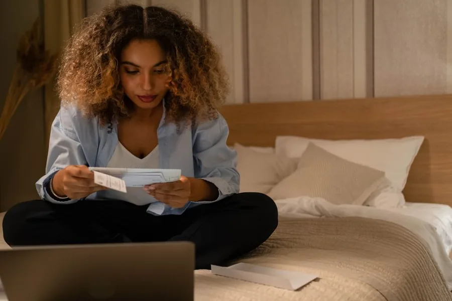 Someone at home checking an HMRC letter against their laptop while working out how to claim a P800 tax refund