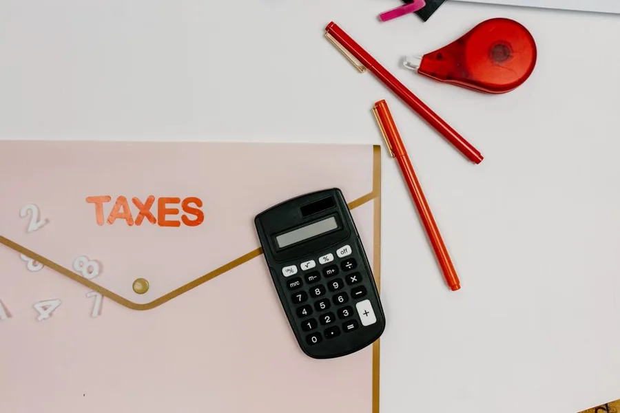 A calculator and pens on a desk as a taxpayer works out an affordable Self Assessment payment plan with HMRC