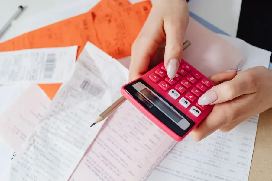 Totting up receipts on a calculator to work out a self assessment tax bill Totting up receipts on a calculator to work out a self assessment tax bill