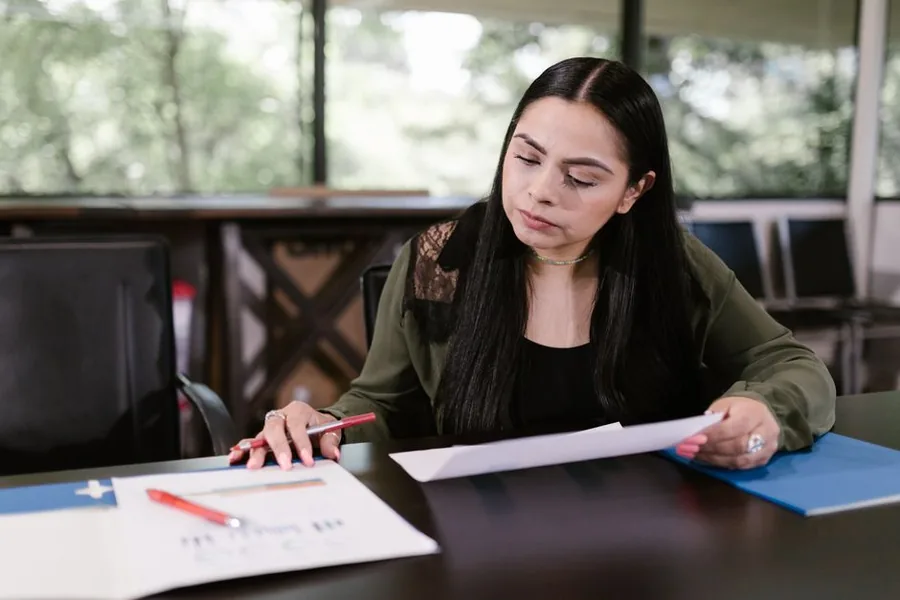 A UK professional reviewing income figures and financial paperwork at her desk to check her tax-free allowances