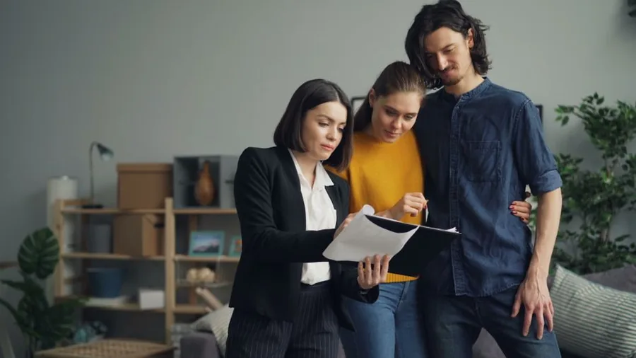 An accountant talking a couple through the capital gains tax due on a property sale, going over the figures together An accountant talking a couple through the capital gains tax due on a property sale, going over the figures together