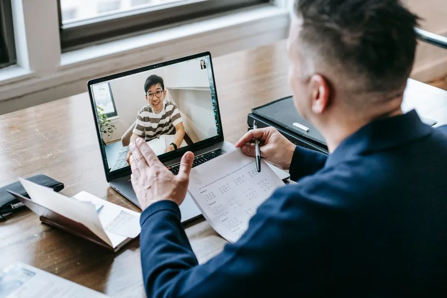 A business owner on a video call with an online accountant, reviewing financial figures together on screen A business owner on a video call with an online accountant, reviewing financial figures together on screen
