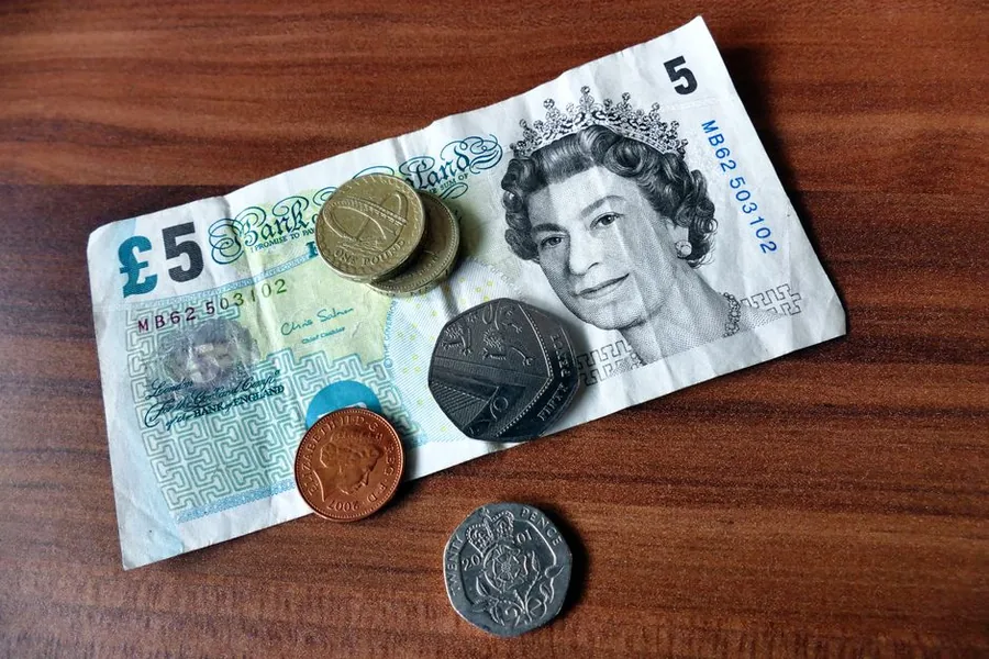 British banknotes and coins on a desk, the takings a sole trader invoices clients for and records for tax British banknotes and coins on a desk, the takings a sole trader invoices clients for and records for tax