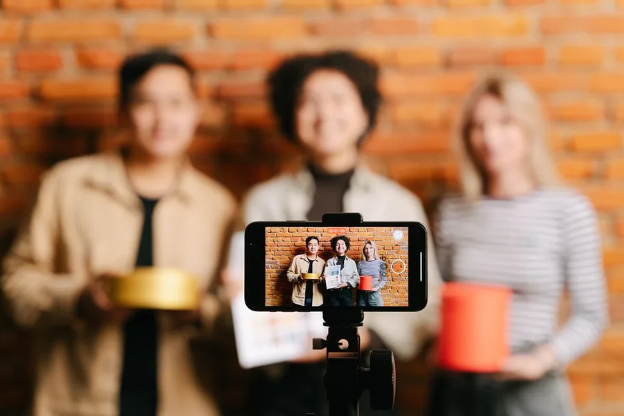 UK content creators filming a product review on a phone, the kind of influencer earnings HMRC expects to be declared