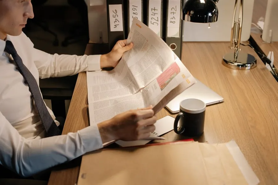 An accountant reviewing a contractor's paperwork against numbered case files during an HMRC IR35 tax investigation An accountant reviewing a contractor's paperwork against numbered case files during an HMRC IR35 tax investigation
