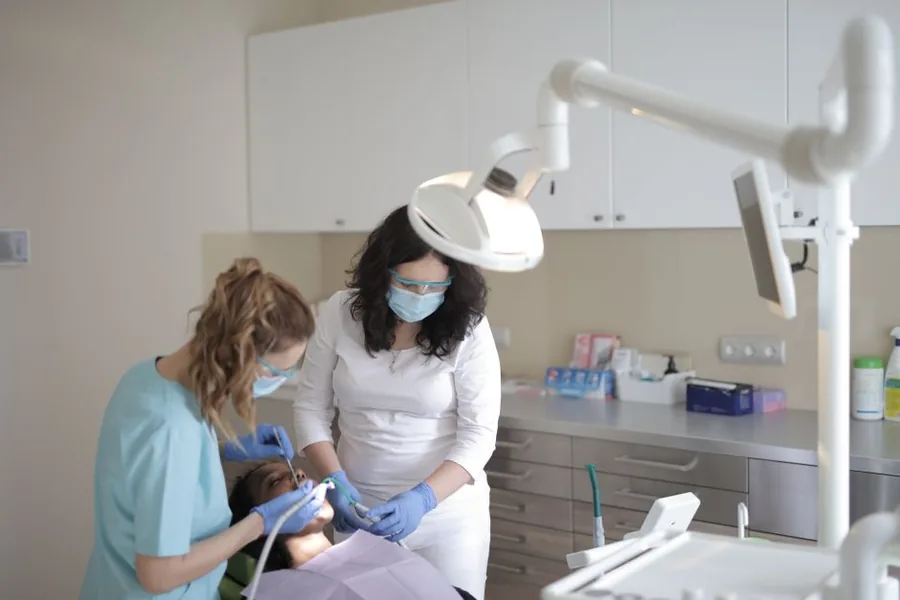 A UK dental practice team treating a patient, the kind of clinical work that determines whether fees are VAT exempt A UK dental practice team treating a patient, the kind of clinical work that determines whether fees are VAT exempt