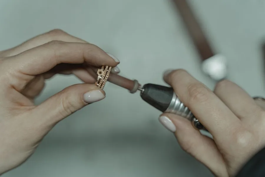 A jeweller finishing a gold ring at the workbench, the kind of repair job an accountant assesses for VAT treatment A jeweller finishing a gold ring at the workbench, the kind of repair job an accountant assesses for VAT treatment