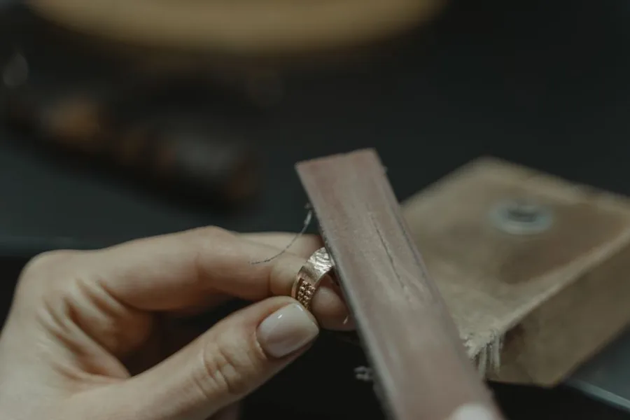 A jeweller polishing a gold ring at their workshop bench, the kind of trade stock covered by block insurance A jeweller polishing a gold ring at their workshop bench, the kind of trade stock covered by block insurance