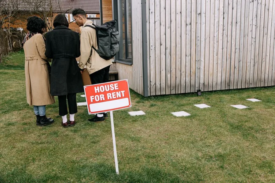 Prospective tenants viewing a UK rental home beside a House for Rent sign, the kind of buy-to-let a landlord weighs holding personally or through a company Prospective tenants viewing a UK rental home beside a House for Rent sign, the kind of buy-to-let a landlord weighs holding personally or through a company