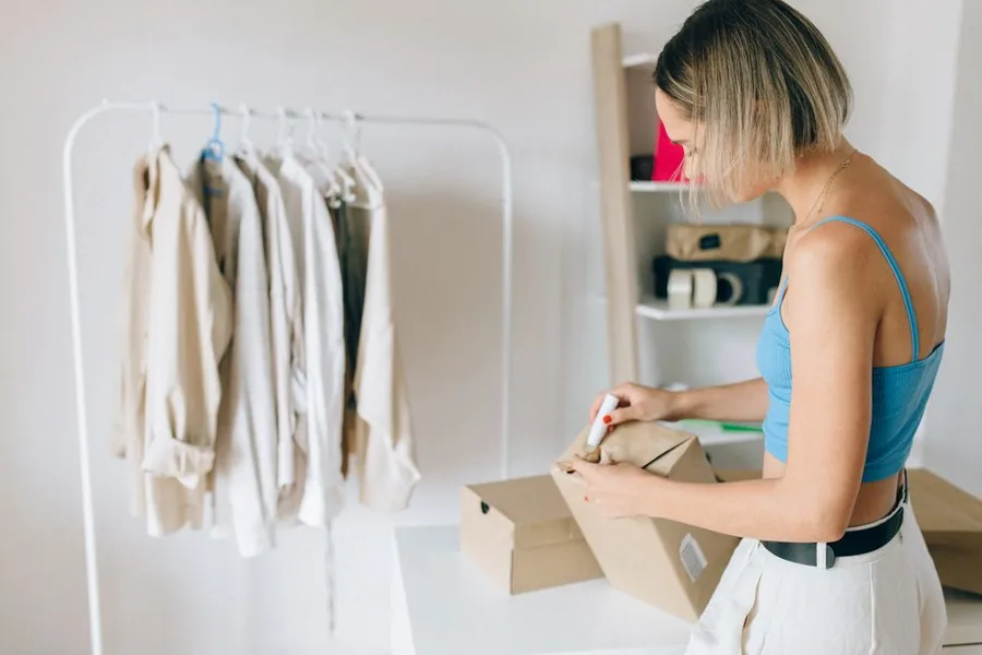 Two ecommerce business owners packing orders and checking their laptop as they prepare stock for the Christmas rush Two ecommerce business owners packing orders and checking their laptop as they prepare stock for the Christmas rush