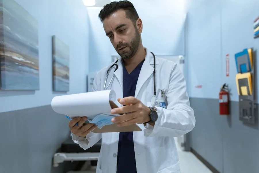A locum doctor going over paperwork with a financial adviser to sort out their tax affairs A locum doctor going over paperwork with a financial adviser to sort out their tax affairs