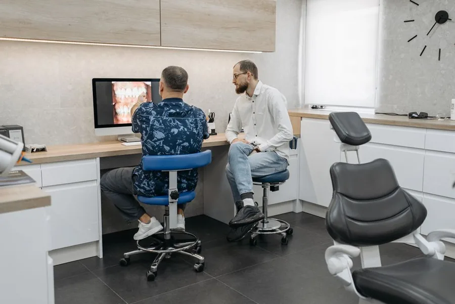 Two UK dentists in a modern surgery comparing notes, reflecting the locum versus associate role choice Two UK dentists in a modern surgery comparing notes, reflecting the locum versus associate role choice