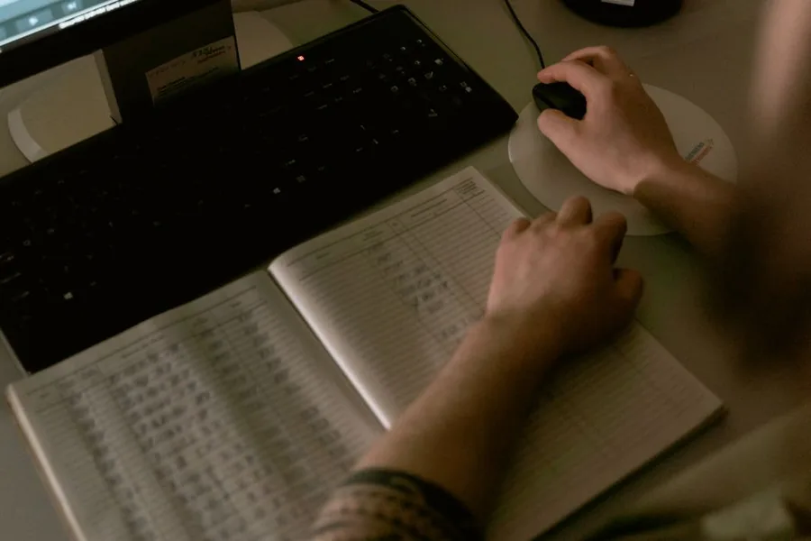A landlord updating rental income records at a computer, shifting from paper ledgers to MTD-compliant digital bookkeeping A landlord updating rental income records at a computer, shifting from paper ledgers to MTD-compliant digital bookkeeping
