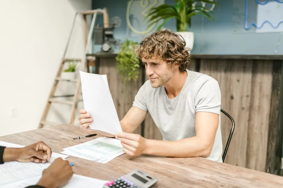 A landlord reviewing rental income paperwork with an accountant, calculator to hand, ahead of an MTD filing deadline A landlord reviewing rental income paperwork with an accountant, calculator to hand, ahead of an MTD filing deadline