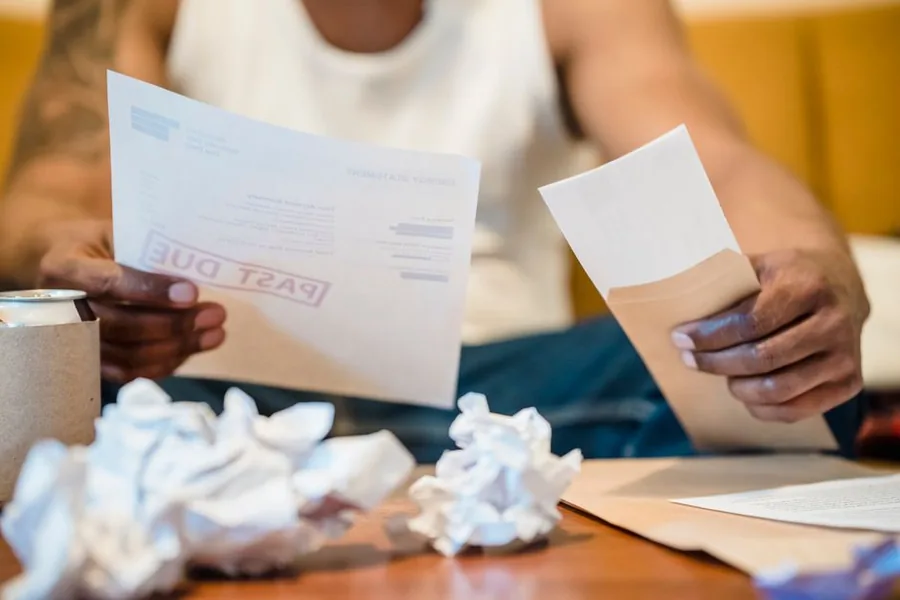 An overdue payment notice held in hand, the kind of reminder landlords receive after missing an MTD tax deadline