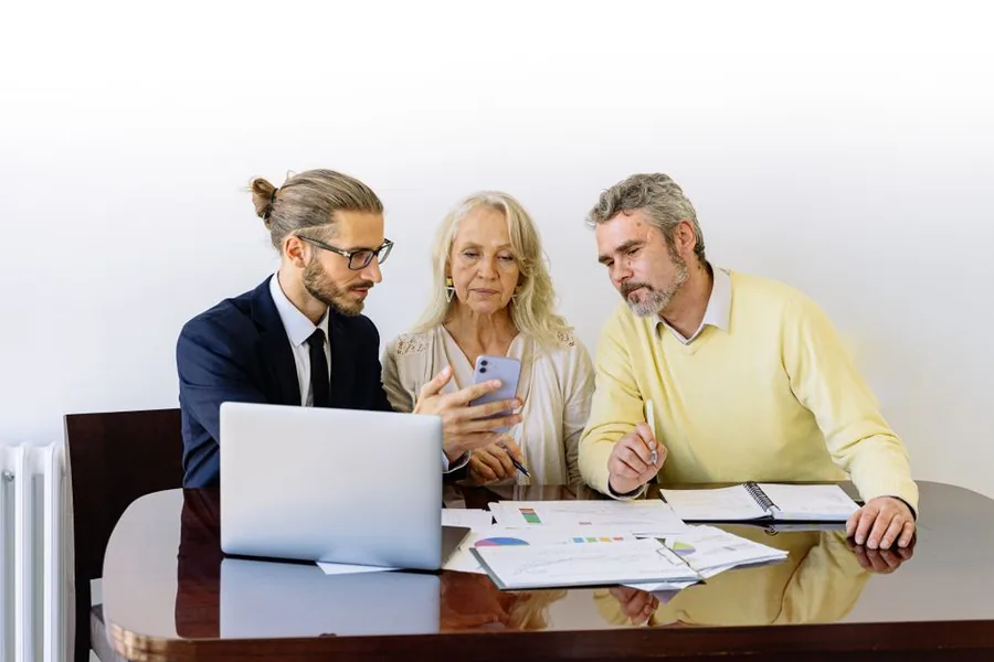 An accountant walking a couple through their digital tax records on a phone and laptop as MTD quarterly reporting begins An accountant walking a couple through their digital tax records on a phone and laptop as MTD quarterly reporting begins