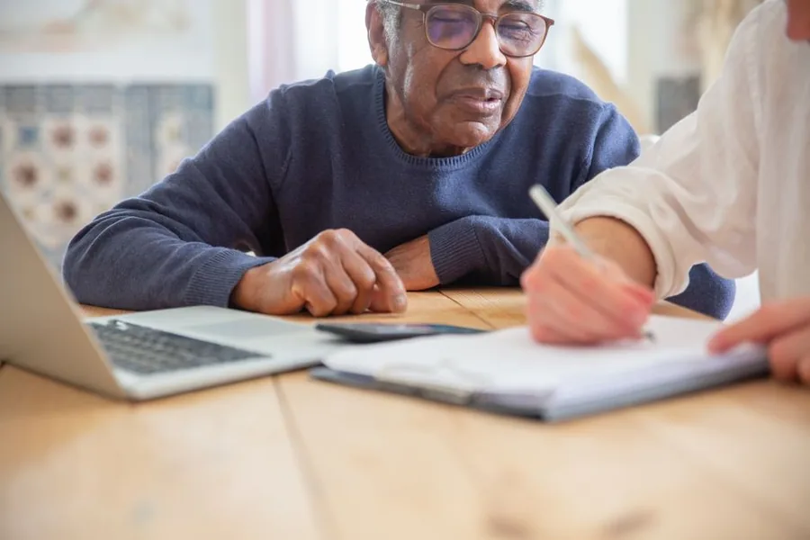 An NHS scheme member reviewing pension paperwork with an adviser to check their annual allowance position