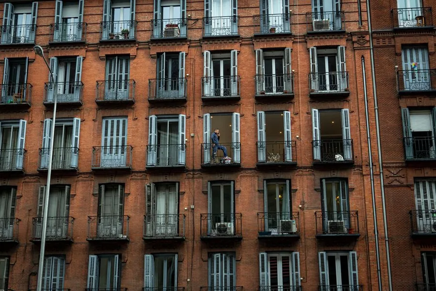 A red-brick residential apartment block with balconies, the kind of let property a non-resident landlord manages from overseas A red-brick residential apartment block with balconies, the kind of let property a non-resident landlord manages from overseas
