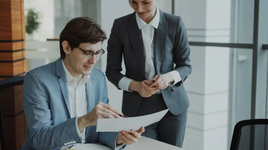 Two business partners reviewing paperwork together before submitting their SA800 partnership tax return Two business partners reviewing paperwork together before submitting their SA800 partnership tax return