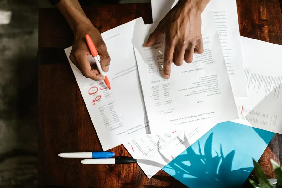 A company director reviewing financial statements in red pen to check retained profit before declaring a dividend A company director reviewing financial statements in red pen to check retained profit before declaring a dividend