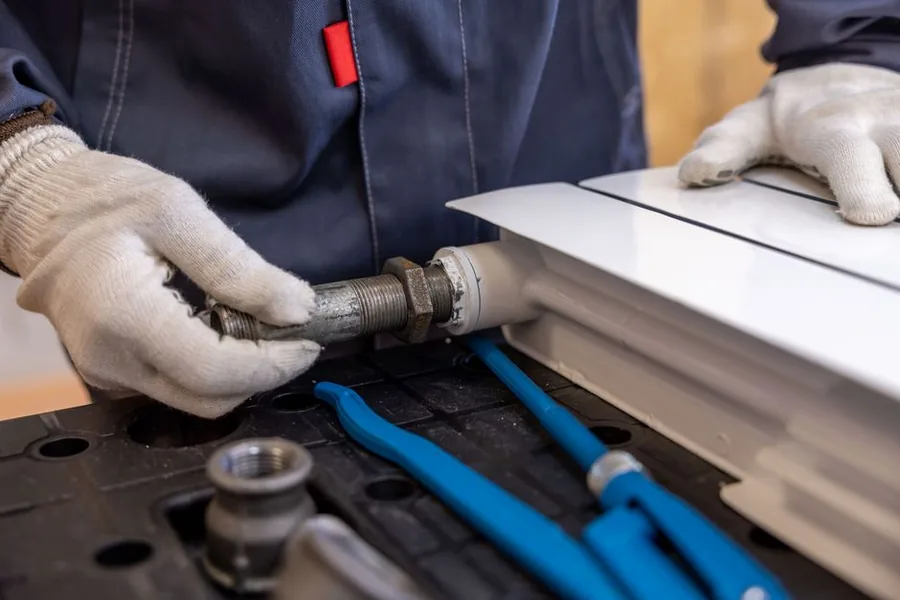 A plumber fitting a radiator pipe with the tools of the trade, the everyday jobs a work van gets driven to A plumber fitting a radiator pipe with the tools of the trade, the everyday jobs a work van gets driven to