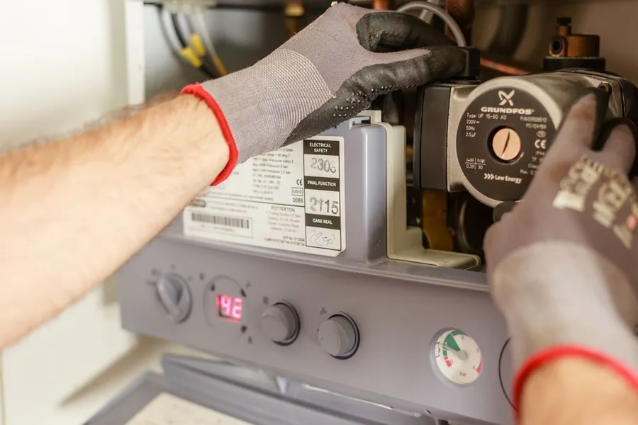 A UK heating engineer servicing a domestic gas boiler, the kind of tools-down job a self-employed plumber logs for tax A UK heating engineer servicing a domestic gas boiler, the kind of tools-down job a self-employed plumber logs for tax