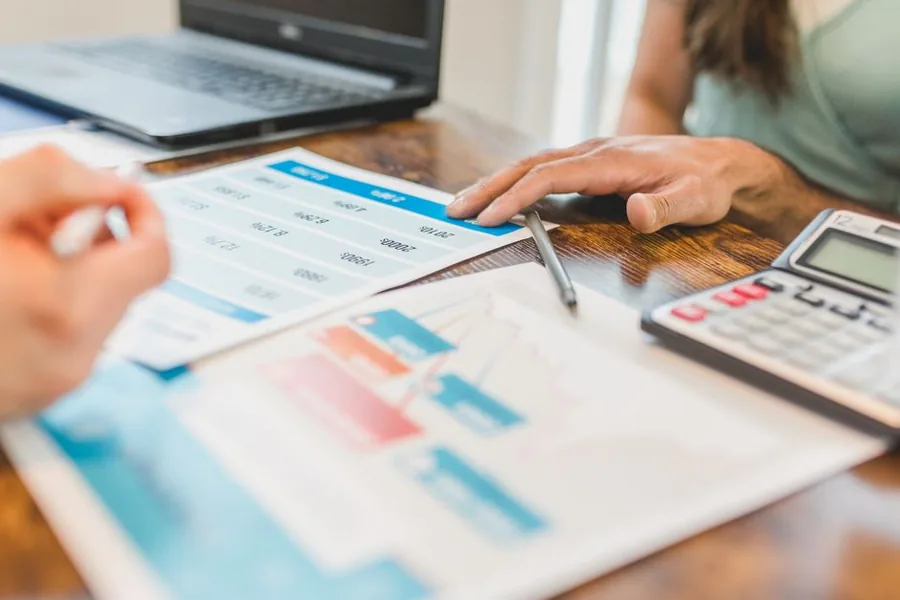 A landlord and accountant reviewing rental income figures to weigh the £1,000 property allowance against claiming actual expenses